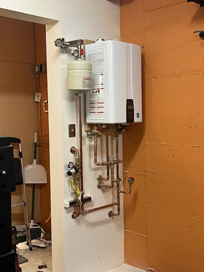 Plumbing technician inspecting water heater connections in Brookhaven